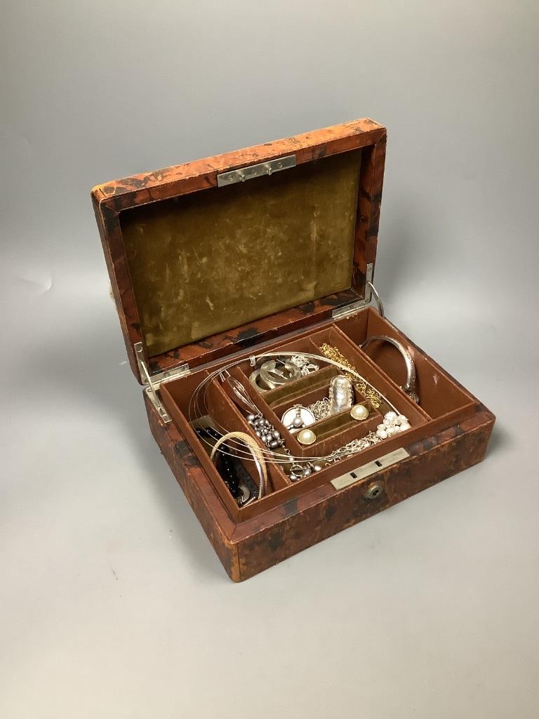 A small leather jewellery box containing assorted silver and other jewellery.